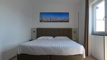 A modern bedroom with a large bed, a cityscape painting on the wall, and a window with curtains.