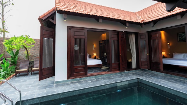 A hotel room with a private pool, wooden doors, and a tiled roof. - Cometa Villas Ninh Bình (Gia Phong)