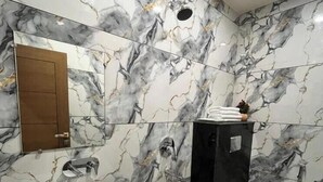 A modern bathroom with a marble backsplash, a large sink, a toilet, and a small cabinet. - Hotel prime bliss (Kanpur)
