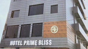A multi-story hotel named "Prime Bliss" with a modern design, featuring a prominent logo and a wooden accent on the lower facade. - Hotel prime bliss (Kanpur)