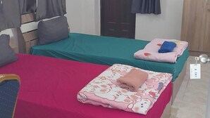 A room with two beds, a desk, an air conditioner, and a wardrobe. - Natcha Place Klongluang 35 (Khlong Luang)