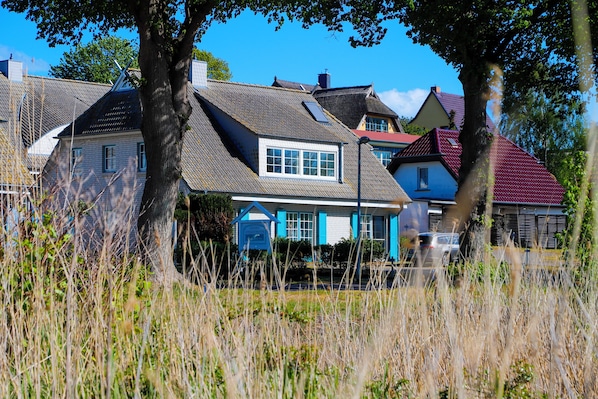 A residential area with houses, including one with a blue facade and a sloped roof.