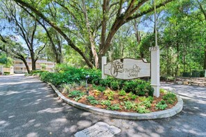 Placa de 'The Loa On Port Royal Sound' com um jardim paisagístico em primeiro plano.