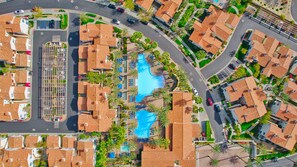 A residential area with multiple houses, a swimming pool, and a parking lot.
