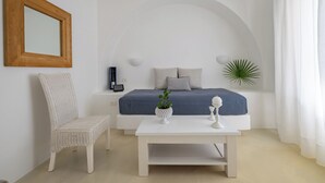 Une chambre à coucher avec un lit, une chaise, une table de chevet, une plante en pot et un miroir au mur.