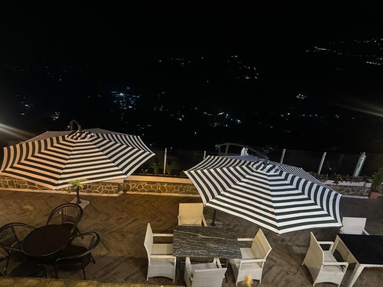 An outdoor seating area with striped umbrellas and wicker furniture.