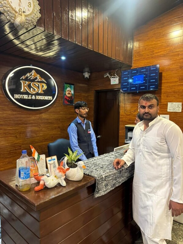 A hotel reception desk with a KSP Hotels & Resorts sign, a security camera, and a digital display. - KSP Royal Valley View Hotel Mussoorie (Mussoorie)