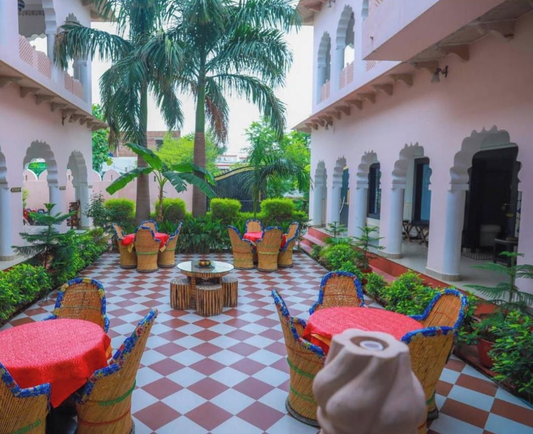 A courtyard with checkered flooring, wicker furniture, and palm trees.