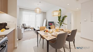 Une cuisine moderne avec un coin repas, un téléviseur et une plante.