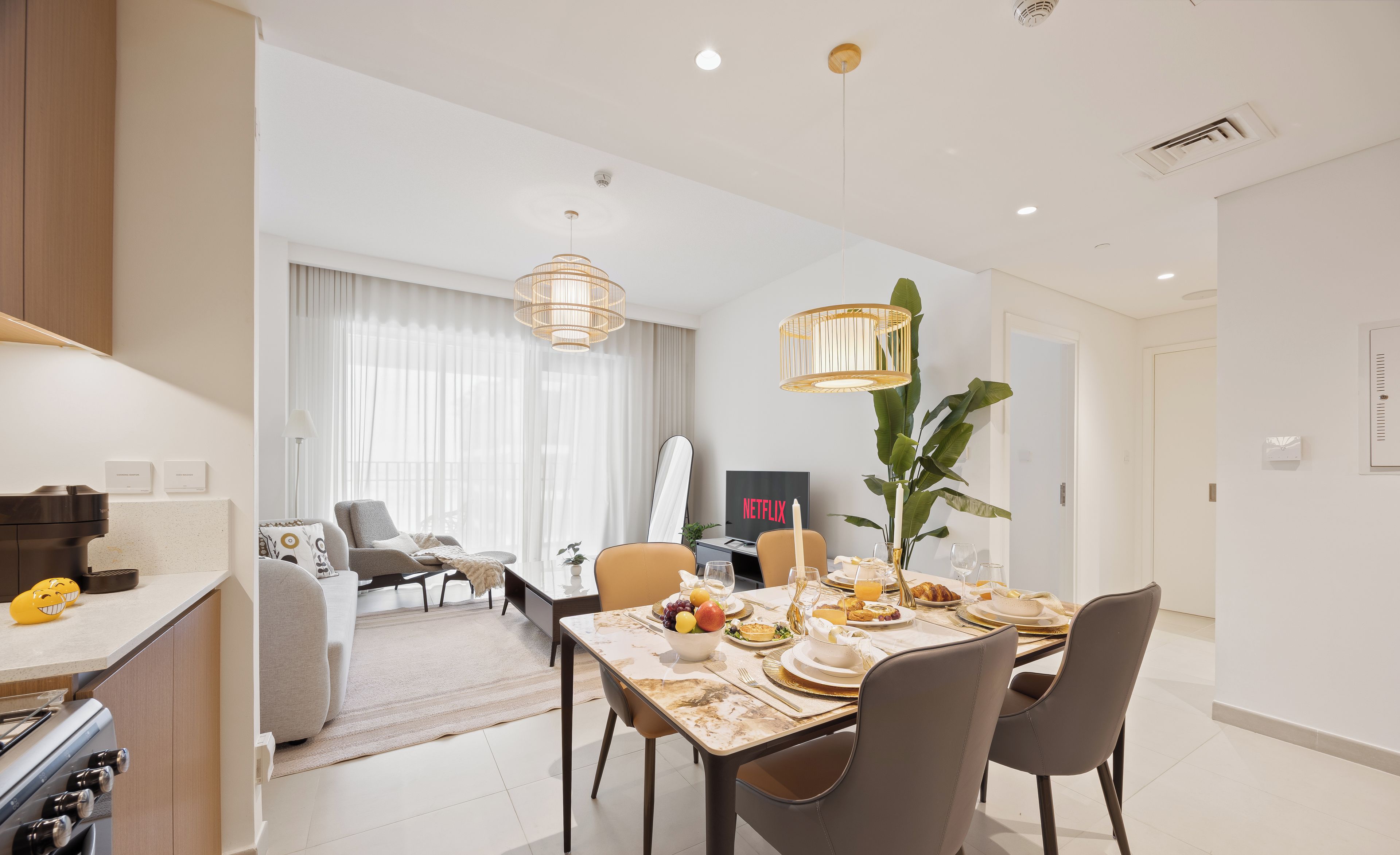 Una cocina moderna con comedor, televisor y planta.