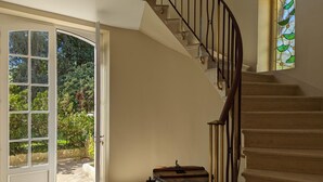 A staircase with a handrail, a door leading outside, and a stained glass window. - Large house with private pool, wifi, pets allowed for 15 guests. (Pranzac)