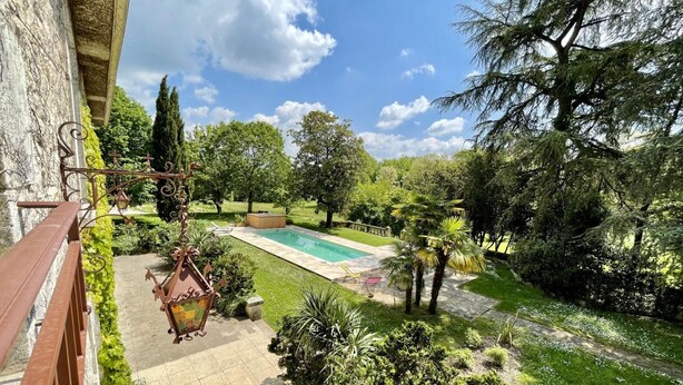 A pool area with a hot tub, surrounded by lush greenery and trees. - Large house with private pool, wifi, pets allowed for 15 guests. (Pranzac)
