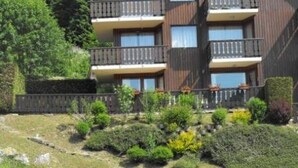 A multi-story building with balconies, surrounded by landscaped gardens and trees. - 3-room Apartment 5 guests - South Terrace, Garage, WiFi, Near shops (Les Gets)