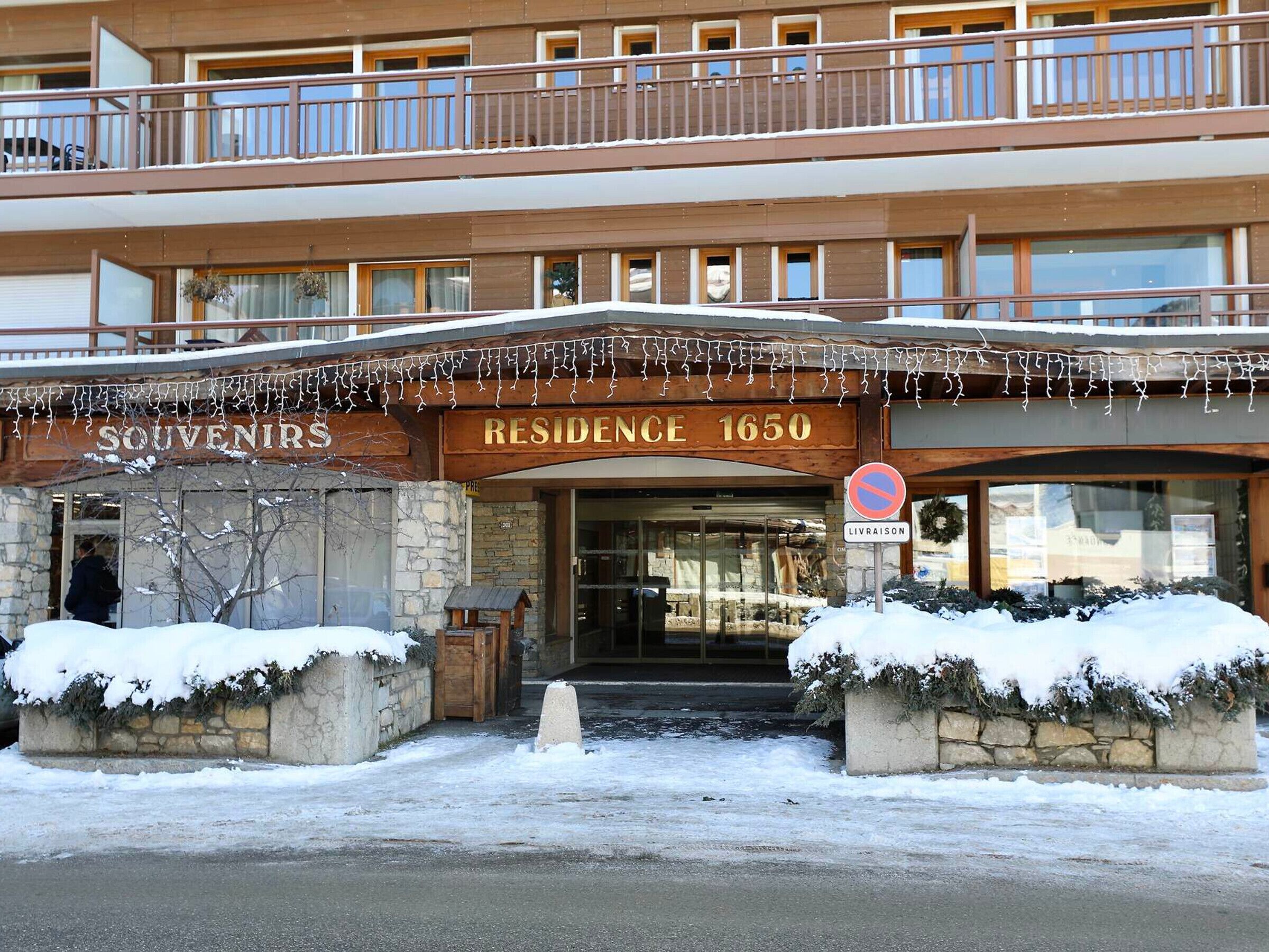 A hotel entrance with a sign reading "RESIDENCE 1650" and a "NO PARKING" sign.