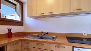 A kitchen with wooden cabinets, a sink, and a Bosch dishwasher. - Slope-side studio in Courchevel 1650 - Terrace with view (Courchevel)