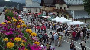 A crowded street with buildings and a church tower.