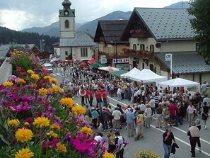 Une rue animée bordée d’immeubles et surmontée d’un clocher d’église.