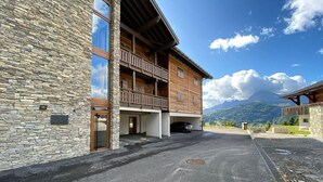 A building with a stone facade and a wooden balcony. - Modern 2-room apartment + cabin, 4 persons, parking (Cohennoz)