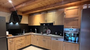 A modern kitchen with wooden cabinets, a stainless steel refrigerator, a built-in oven, and a dishwasher. - Châtel: 3-Room Apt, Terrace, 5 Pers, Private Parking (Châtel)