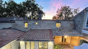A courtyard with a tiled roof, a small wooden table, and a bench. - The Loft Factory 4 Bedrooms Garonne View + Garden (Lormont)