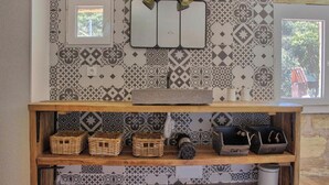 A bathroom with patterned tiles, a mirror, a shelf with baskets, and a window. - The Loft Factory 4 Bedrooms Garonne View + Garden (Lormont)
