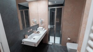 Deluxe driepersoonskamer | Badkamer | Een douche, een haardroger, pantoffels, een bidet