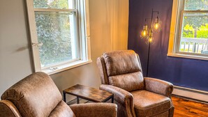 A room with two brown leather armchairs, a small wooden table, and a floor lamp. - Elk Creek Farmhouse near Penn State! (Millheim)