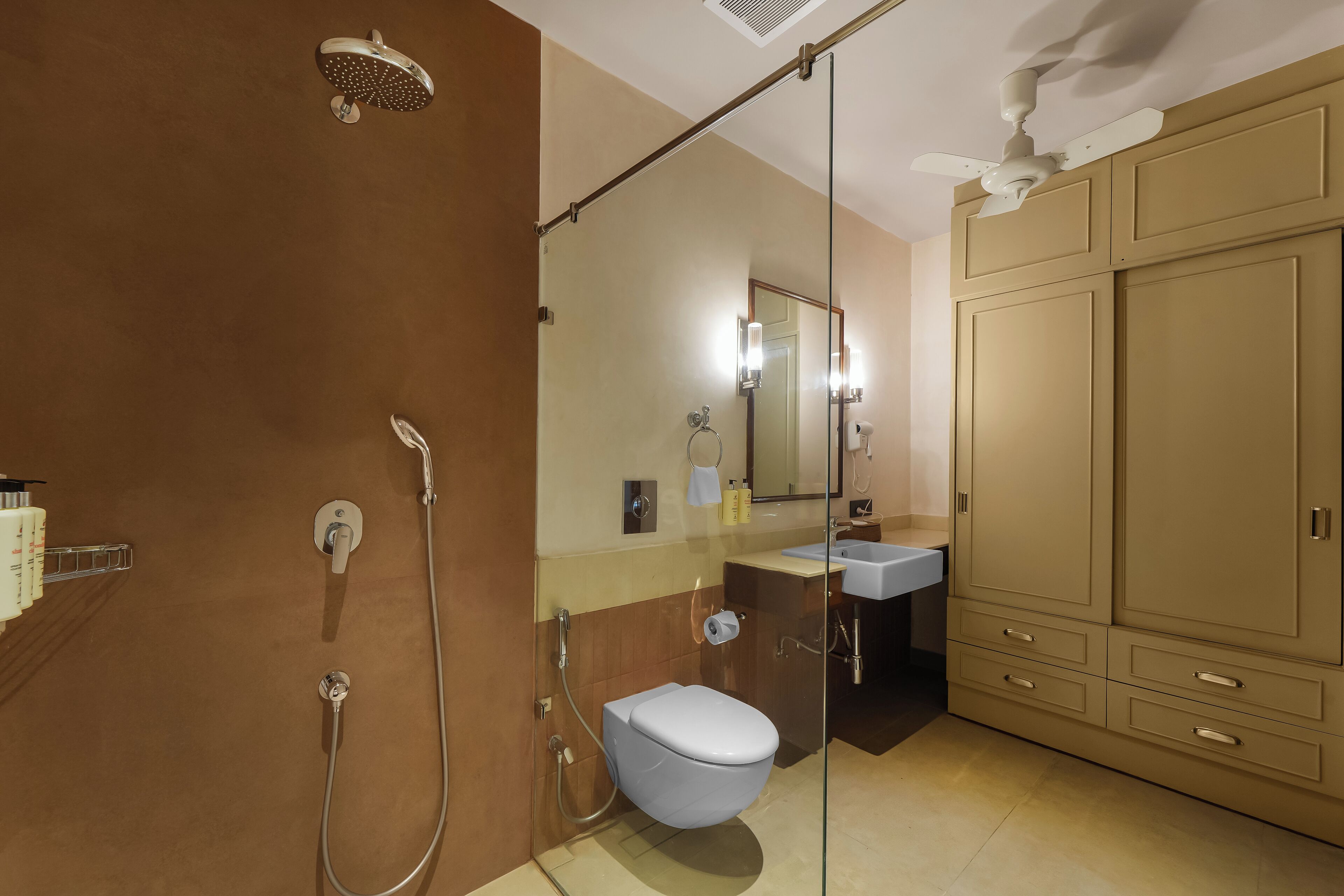 A modern bathroom with a glass-enclosed shower, a toilet, and a vanity with a mirror.