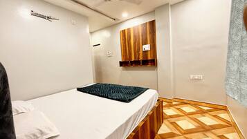 Un dormitorio con cama, armario de madera y suelo estampado.