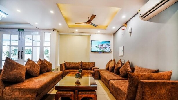 A modern living room with a sofa set, a coffee table, and a ceiling fan.