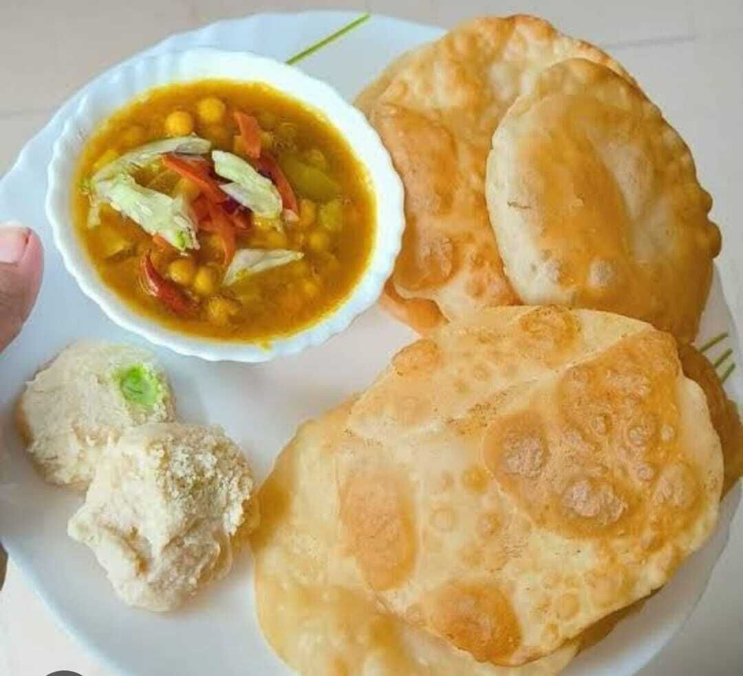 A plate with three pieces of fried bread, a bowl of soup with vegetables, and a small piece of bread.
