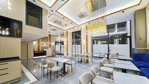 A modern hotel lobby with a reception desk, seating areas, and a large chandelier. - Elysia Hotel (Istanbul)