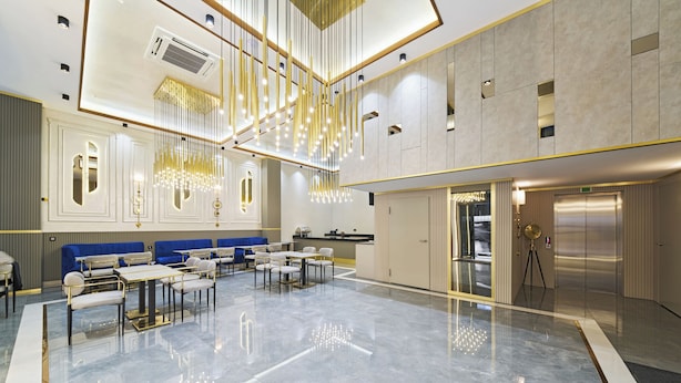 A spacious lobby with a high ceiling, modern chandeliers, seating areas, and a large mirror reflecting the space. - Elysia Hotel (Istanbul)