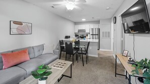 A modern apartment with a living room, dining area, and kitchen. - Cozy Contemporary Stay I Pool & Gym I Free Parking (Fayetteville)