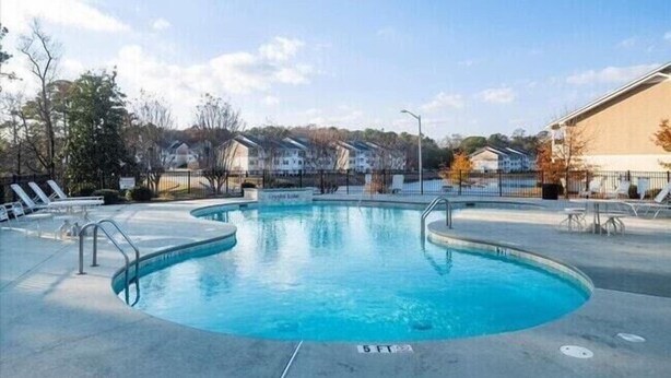 A swimming pool with lounge chairs and a clear sky. - Cozy Contemporary Stay I Pool & Gym I Free Parking (Fayetteville)