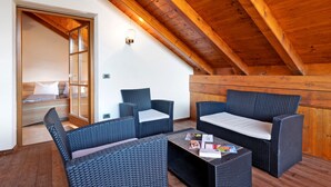 Une pièce chaleureuse avec des poutres en bois, des meubles en osier et un lit.