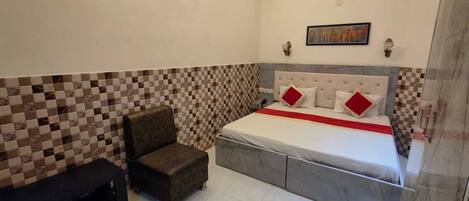 A bedroom with a bed, a bench, and a tiled wall.