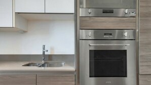 A kitchen with a stainless steel oven, a built-in microwave, and a sink.