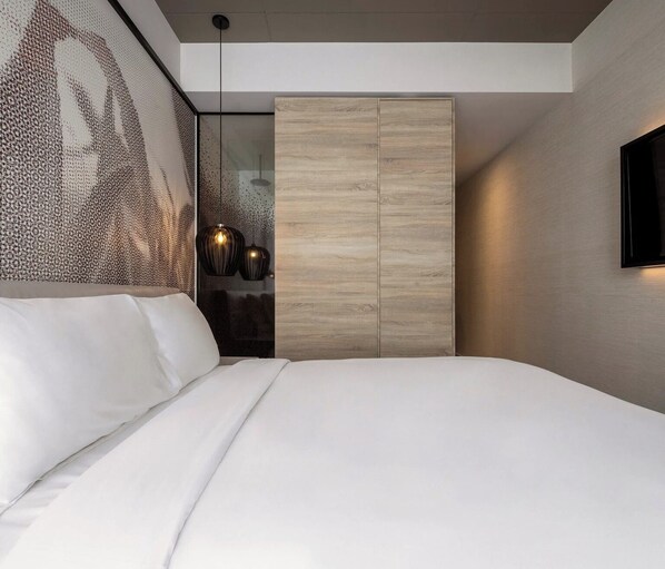 A modern bedroom with a large bed, a wooden wardrobe, and a wall-mounted TV.