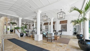 Eine geräumige Lobby mit hoher Decke, großen Säulen und modernen Beleuchtungselementen.