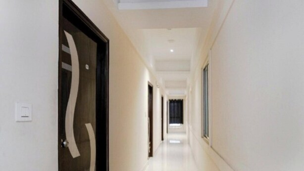 Un pasillo con un diseño moderno de puerta, piso de color claro e iluminación empotrada en el techo.