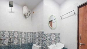 Un baño con inodoro, lavamanos y ducha.