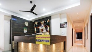 Una recepción con un reloj, un ventilador de techo y un cartel del Hotel Sal Leila Residency.
