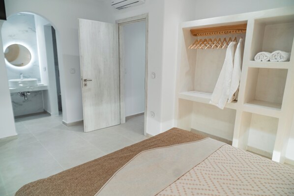Un baño moderno con un espejo redondo, un lavabo y un perchero para toallas.