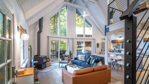 A spacious loft-style living area with a large sofa, a dining table, and a kitchen area.
