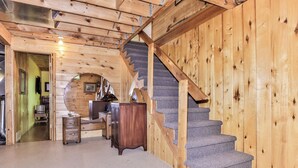 Un interno in legno con una scala, una scrivania e una sedia.