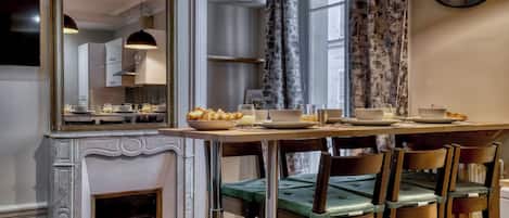 A dining area with a table set for breakfast, a fireplace, and a large mirror.