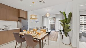 A modern apartment with a dining area, kitchen, and living space. - WYZ RENT|Earthy Elegant 1BR Surf 2 Creek Beach (Dubai)