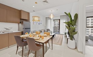 Un appartement moderne comprenant un coin repas, une cuisine et un espace de vie.
