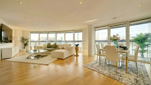 A spacious living room with a sofa, coffee table, and dining area.